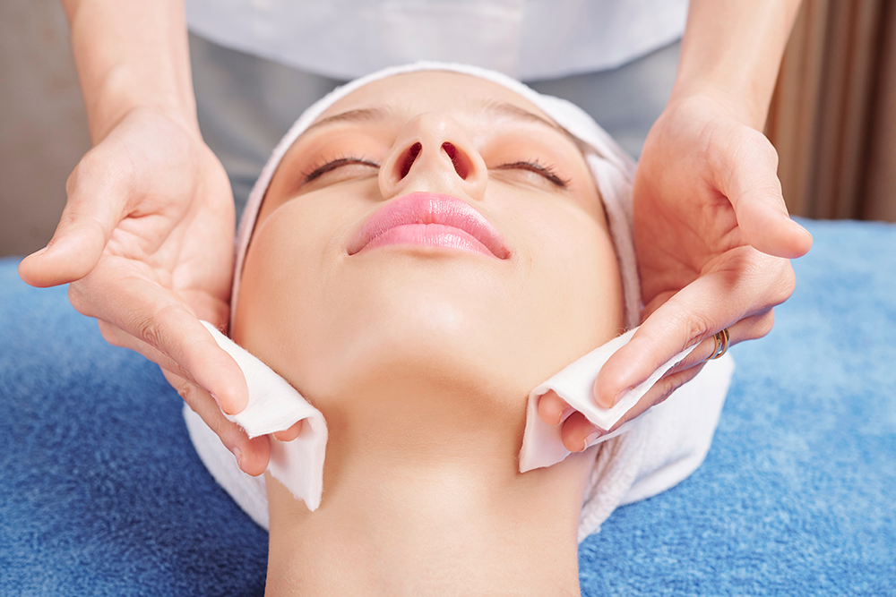 Esthéticienne appliquant une lotion tonique sur un visage