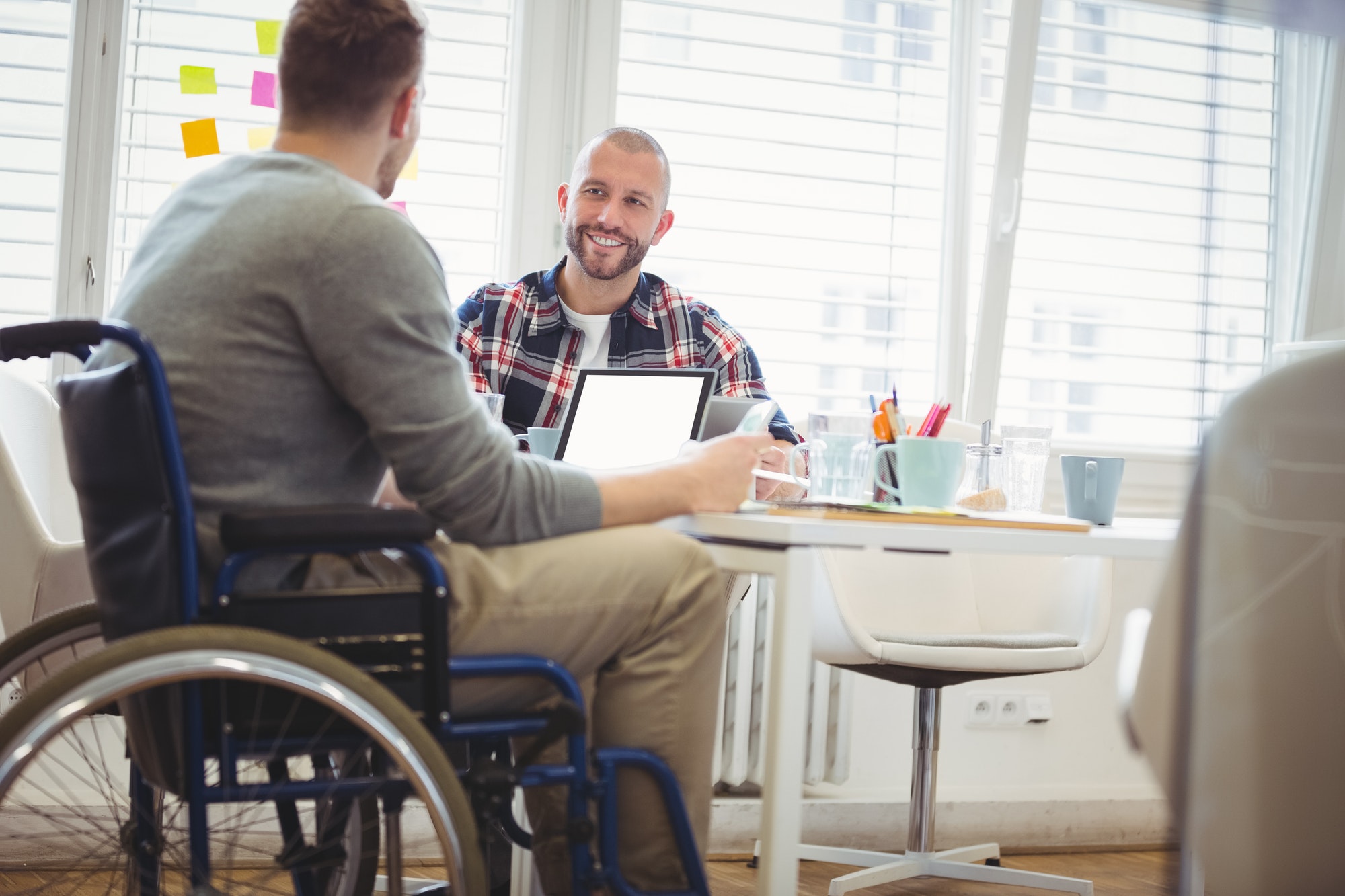 Handicap businessman discussing with colleague in office